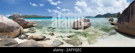 Big stones on the beach of the Seychelles and clear water Stock Photo