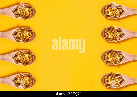 Medical background. Fish oil in a wooden spoons. Central composition. Stock Photo