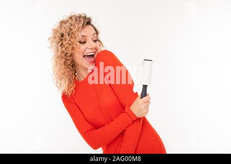 blond girl cleans her clothes from wool on a white background. Stock Photo