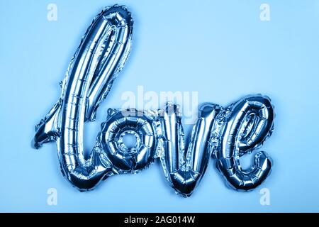 Love foil balloon on monochrome colorful backdrop. Valentines day concept. Stock Photo