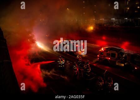 New York City Firefighters douse a car fare on Brooklyn, NY's Brooklyn Queens Expressway Stock Photo