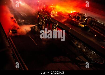 New York City Firefighters douse a car fare on Brooklyn, NY's Brooklyn Queens Expressway Stock Photo