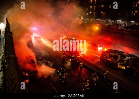 New York City Firefighters douse a car fare on Brooklyn, NY's Brooklyn Queens Expressway Stock Photo