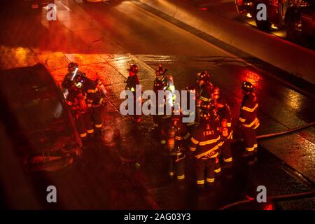 New York City Firefighters douse a car fare on Brooklyn, NY's Brooklyn Queens Expressway Stock Photo