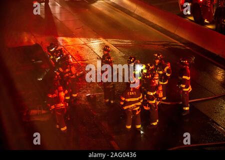 New York City Firefighters douse a car fare on Brooklyn, NY's Brooklyn Queens Expressway Stock Photo