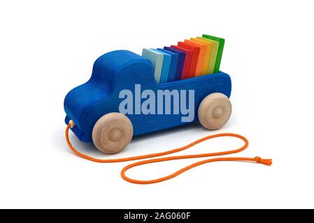 Wooden toy pickup truck in blue carrying colored tiles classified as a rainbow on white background. Stock Photo