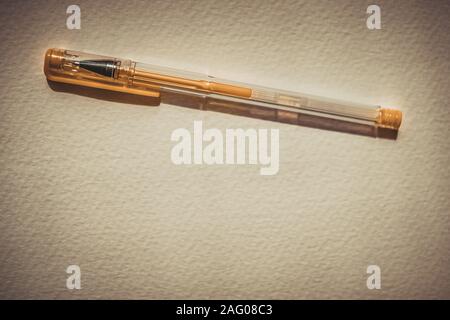 Yellow gel pen on white textured paper, copy space. Stock Photo