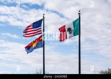 Tucson, AZ - Nov. 26, 2019: The flags of Mexico, United States, and the state of Arizona fly over the Arizona-Sonora Desert Museum to reflect the fact Stock Photo
