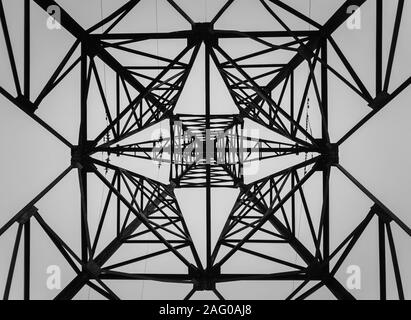 Underneath a truss pillar construction. Different geometric shapes, patterns of a steel structure. Metallic texture of an electricity pole. Stock Photo