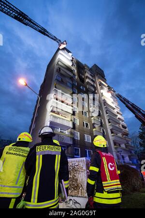 17 December 2019, Hessen, Frankfurt/Main: During a domestic fire, firefighters of the fire brigade are standing in a high-rise building at the scene of the fire. At first, nothing was known about possible injuries. Photo: Boris Roessler/dpa Stock Photo