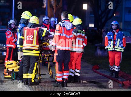 17 December 2019, Hessen, Frankfurt/Main: During a domestic fire, firefighters of the fire brigade are standing in a high-rise building at the scene of the fire. At first, nothing was known about possible injuries. Photo: Boris Roessler/dpa Stock Photo