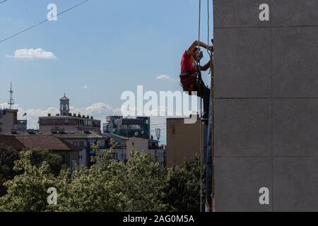 Man washing windows connected to the rope Stock Photo