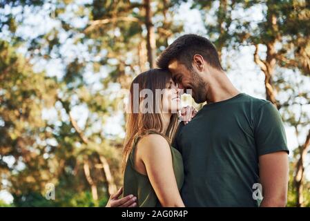 Beautiful young couple have a good time in the forest at daytime