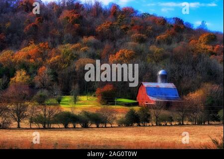 Autumn colors surrounds this landscape of agricultural land with a barn and silo. Stock Photo