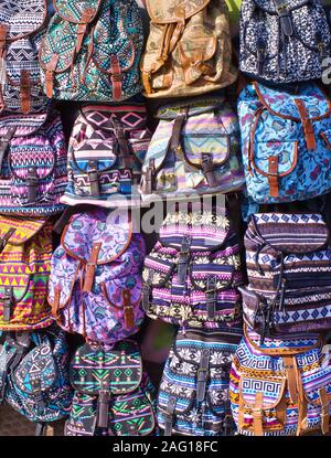 Colorful textile bags with geometrical shapes hanging on exterior store wall, in Monastiraki area, Athens, Greece. Vertical seamless background. Stock Photo