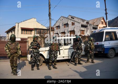 Indian paramilitary forces stand on guard during the clashes in downtown area of Srinagar.Police used teargas smoke canisters and pellets to disperse the Kashmiri students protesting in solidarity with students of Aligarh Muslim University (AMU) and Jamia Millia Islamia Delhi, were violent clashes left dozens students injured. The Kashmiri students also demonstrated against the Citizenship Amendment Act (CAA). Stock Photo