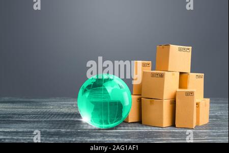 Light green globe and cardboard boxes. Economic relations commerce. Freight transportation. Distribution and trade exchange goods around the world, re Stock Photo