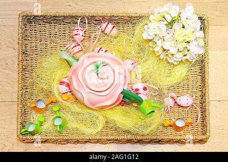 Rattan tray with pink teapot and Easter theme Stock Photo