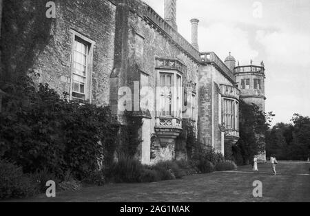 Lacock Abbey, Lacock, Wiltshire, England, UK: south elevation with oriel windows and Sharington's Tower at the end.  Old black and white film photograph Stock Photo