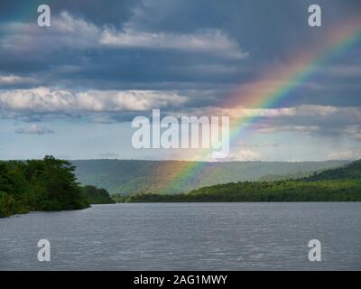 After heavy rain a rainbow forms over the river at Tatai in Koh Kong Province, Cambodia Stock Photo