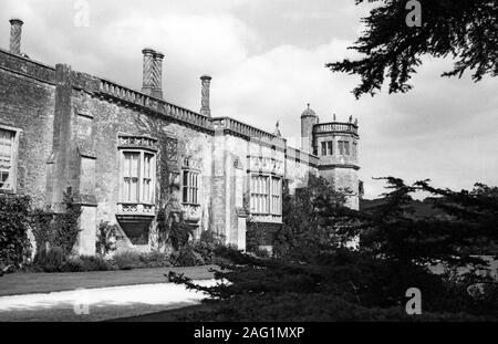 Lacock Abbey, Lacock, Wiltshire, England, UK: south elevation with oriel windows and Sharington's Tower at the end.  Old black and white film photograph Stock Photo