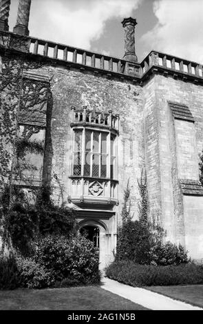 Lacock Abbey, Lacock, Wiltshire, England, UK: south elevation with old door to the cloisters and mullioned window above: the window featured in Henry Fox Talbot's ground-breaking first negative photograph of 1835.  Old black and white film photograph Stock Photo