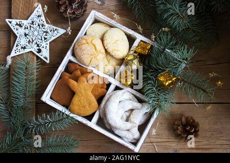 Assorted Christmas cookies and Christmas decorations in a wooden box on a wooden background. Rustic style. Stock Photo