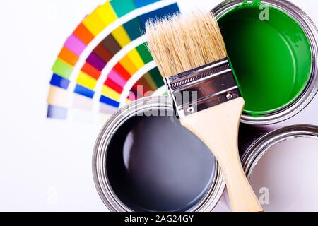 Open tin cans with paint, brushes and palette isolated on white Stock Photo