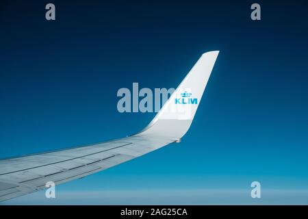 Amsterdam, Netherland - November, 2019: Airplane wing and company brand logo of KLM airlines isolated on blue sky Stock Photo