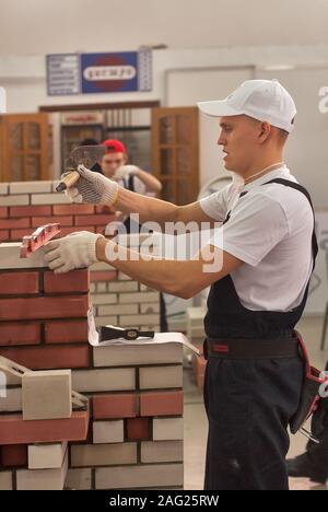 Young bricklayer performs a task of competition Stock Photo