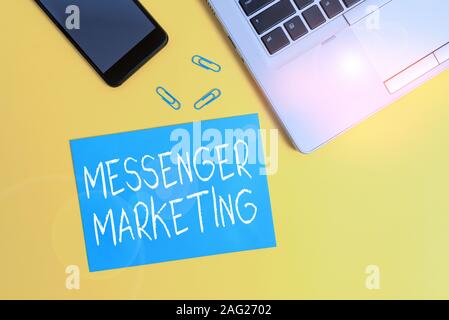 Text sign showing Messenger Marketing. Business photo showcasing act of marketing to your customers using a messaging app Trendy open laptop smartphon Stock Photo