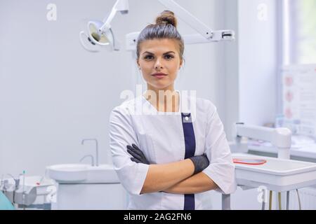 Portrait of young confident dentist doctor woman, female with arms crossed Stock Photo
