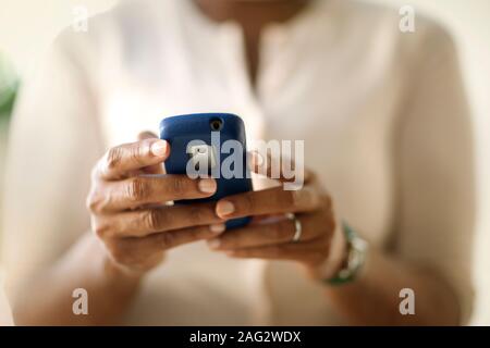 Businesswoman sending a text message on a cell phone. Stock Photo