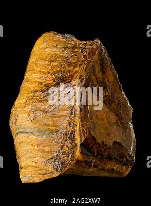 Raw, uncut tiger's eye (also called tiger eye) mineral isolated on black background Stock Photo