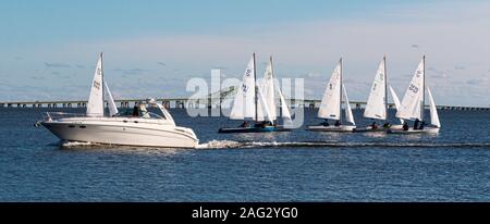 Babylon, New York, USA - 7 December 2019: A snowflake sailboat regatta in December 2019 in The Great South Bay has many two person sailboats and a mot Stock Photo