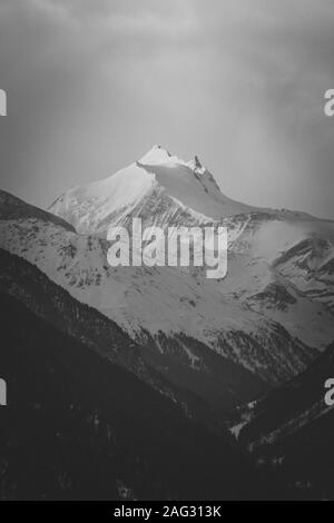 Vertical greyscale shot of snowy mountains under the clear sky Stock Photo