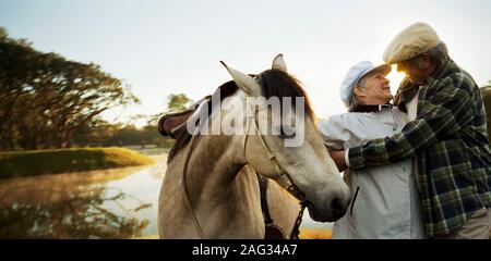 Senior couple sharing an intimate moment with beautiful lake in the background. Stock Photo