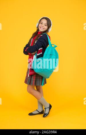 ebook and private lesson concept. small girl headset with backpack. kid with english flag on jacket. study english language online. british school in england. learning English with audio book. Stock Photo