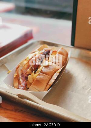 Vertical shot of a delicious of an egg and bacon sandwich on a metal tray Stock Photo