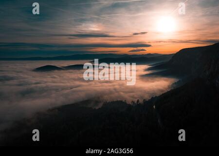 mountain landscape during sunset with a lot of fog Stock Photo
