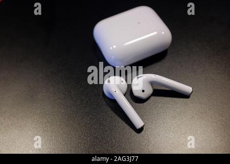 Closeup shot of a pair of air pods and a charging case on a black background Stock Photo
