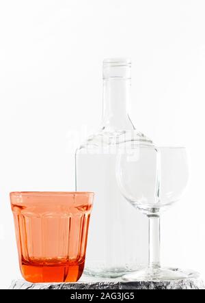 Verticals hot of an empty bottle and glasses on white background