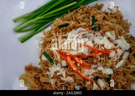 Asian eating food, Mee Grob is an sweet and sour crispy noodles, made from Thai rice noodle with sweet and sour sauce on white plate, Sweet & Sour Cri Stock Photo
