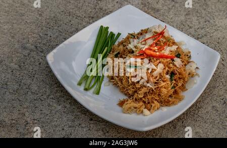 Asian eating food, Mee Grob is an sweet and sour crispy noodles, made from Thai rice noodle with sweet and sour sauce on white plate, Sweet & Sour Cri Stock Photo