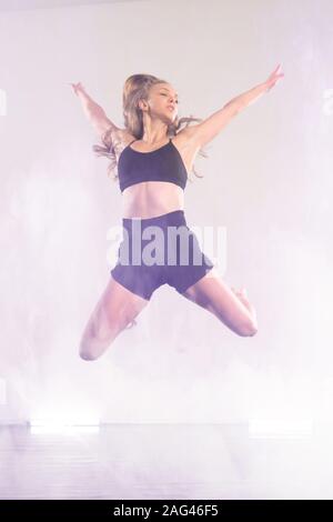 Young modern dancer dancing in the studio. Sport, dancing and urban culture concept. Group of young dancers performing on the stage. Effective perform Stock Photo