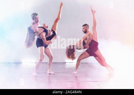 Young modern dancers dancing in the studio. Sport, dancing and urban culture concept. Group of young dancers performing on the stage. Effective perfor Stock Photo