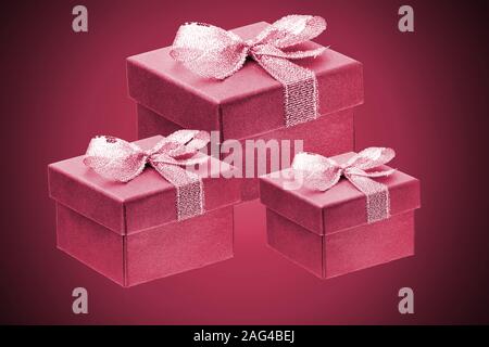 three purple gift boxes on a red gradient background. close up. Stock Photo