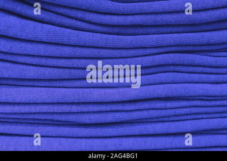 clothes stacked close-up, fabric texture, bright colors, neat blue stacks. Stock Photo