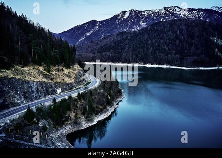 Fascinating scenery of a blue lake surrounded by mountainous forests in winter