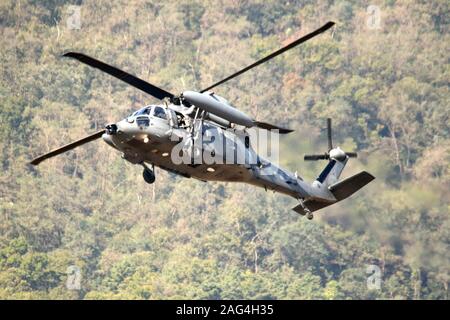 Low angle closeup shot of a Sikorsky UH-60 Black Hawk flying above a forest Stock Photo